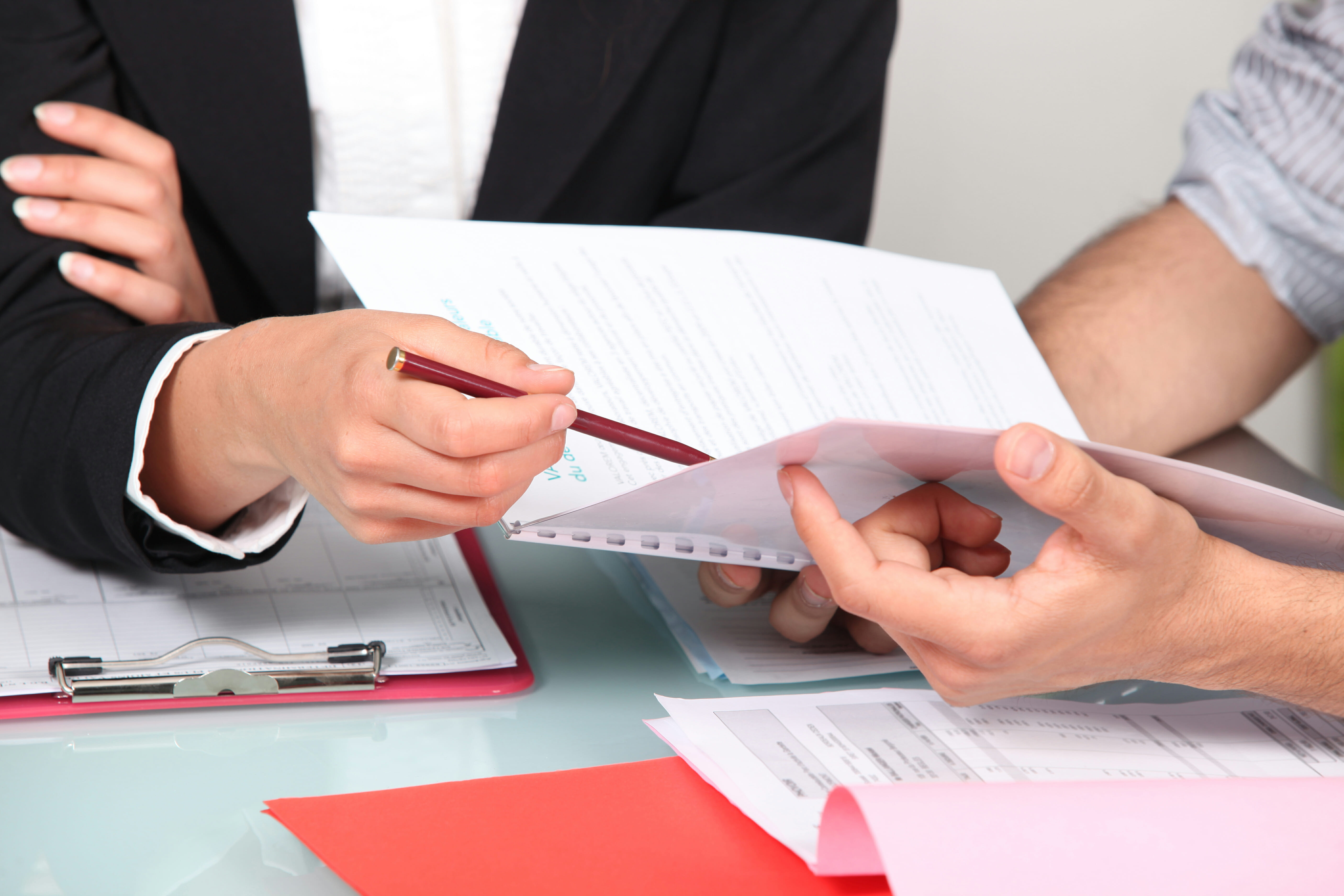 Two professionals reviewing documents together at a desk.