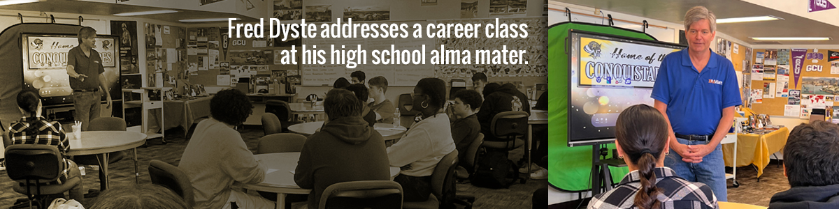 A speaker addresses students at a career class in a high school auditorium.